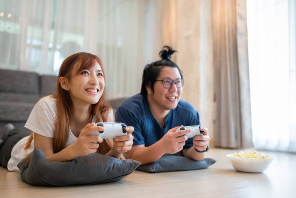 istock Happy Asian couple lying on front playing new released video game on the weekend 1749813175