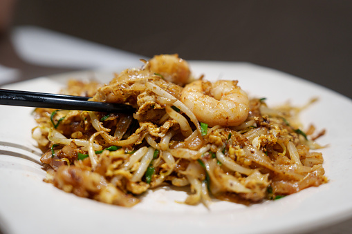 Wok-fried rice noodles with scallop, egg, bean sprouts, prawns, chives, soy sauce, and chili paste, a popular Penang street food