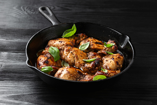 Baked balsamic chicken thighs in cast iron pan.