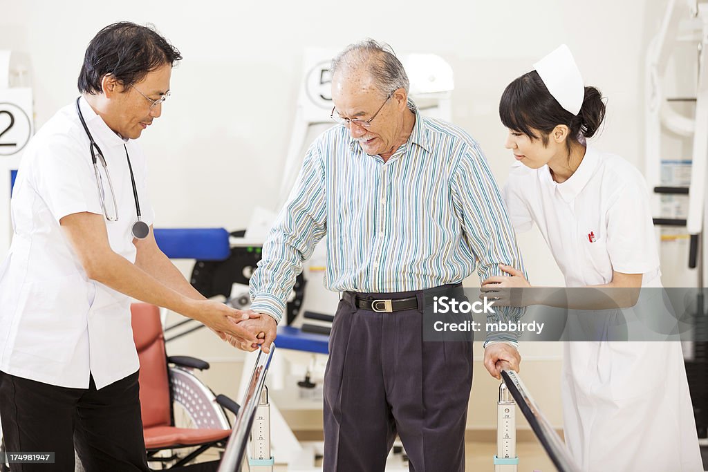 Japanese doctor and nurse training senior man on paralel bars Japanese doctor and nurse training senior man on paralel bars in rehab room. Shallow DOF, selective focus on patient. Taken on iStockalypse Tokyo, Japan, 2010. http://santoriniphoto.com/Template-istockalypse-tokyo-2010.jpg Recovery Stock Photo