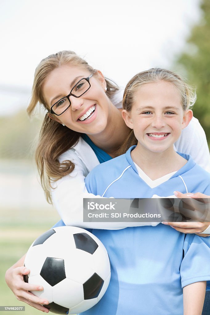 Madre con figlia in posa prima partita di calcio - Foto stock royalty-free di Mamma che ama il calcio