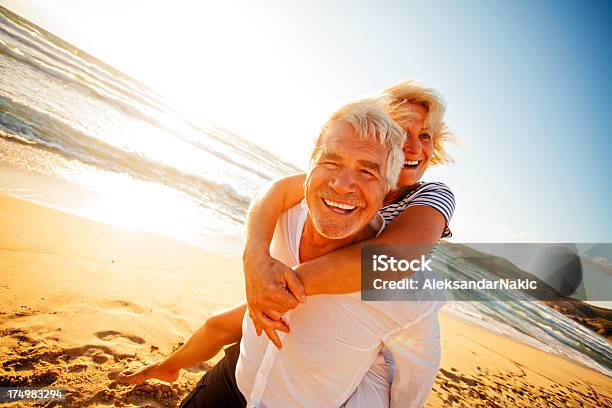 Active Seniors Stock Photo - Download Image Now - Piggyback, Senior Couple, Beach