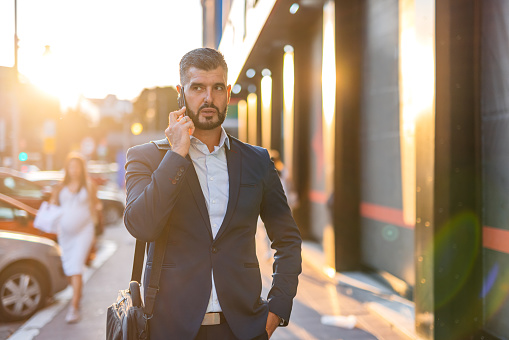 Handsome mid-adult man talking on his smart phone in the city.