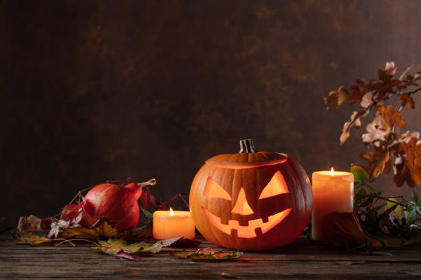 istock Halloween pumpkin head jack lantern with dried-up leaves. 1749840688