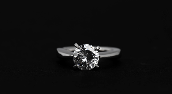 Close up of a diamond ring on black background.