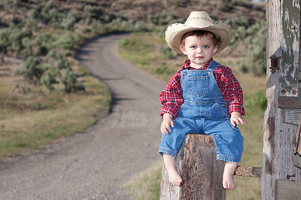 istock Little Boy Outdoors in Blue Denim Overalls Wearing Cowboy Hat 174984537