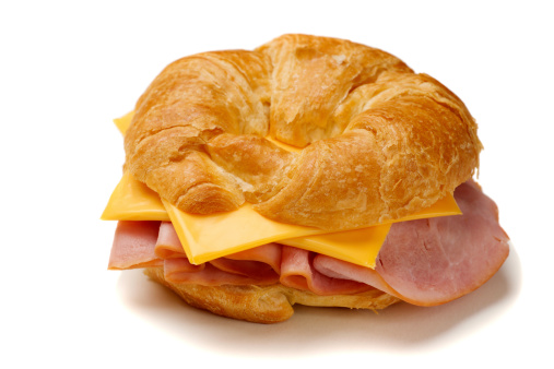 Ham and cheese croissant on white background.