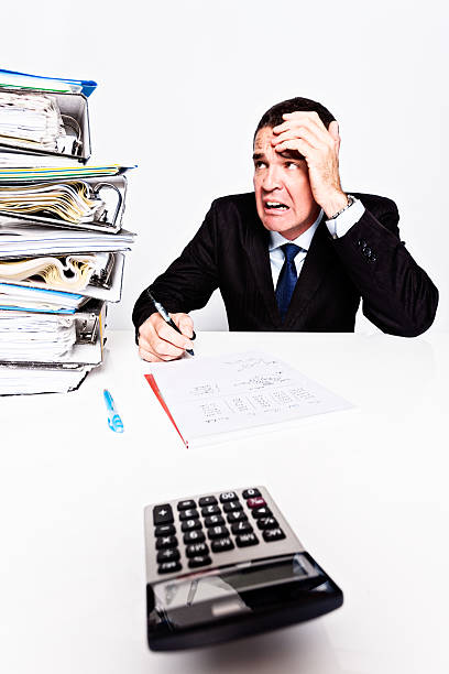 istock Overwhelmed businessman grimaces at huge work overload 174985192