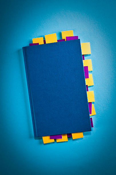 istock Blue notepad with yellow and purple sticky post-it, vignetting 174985292