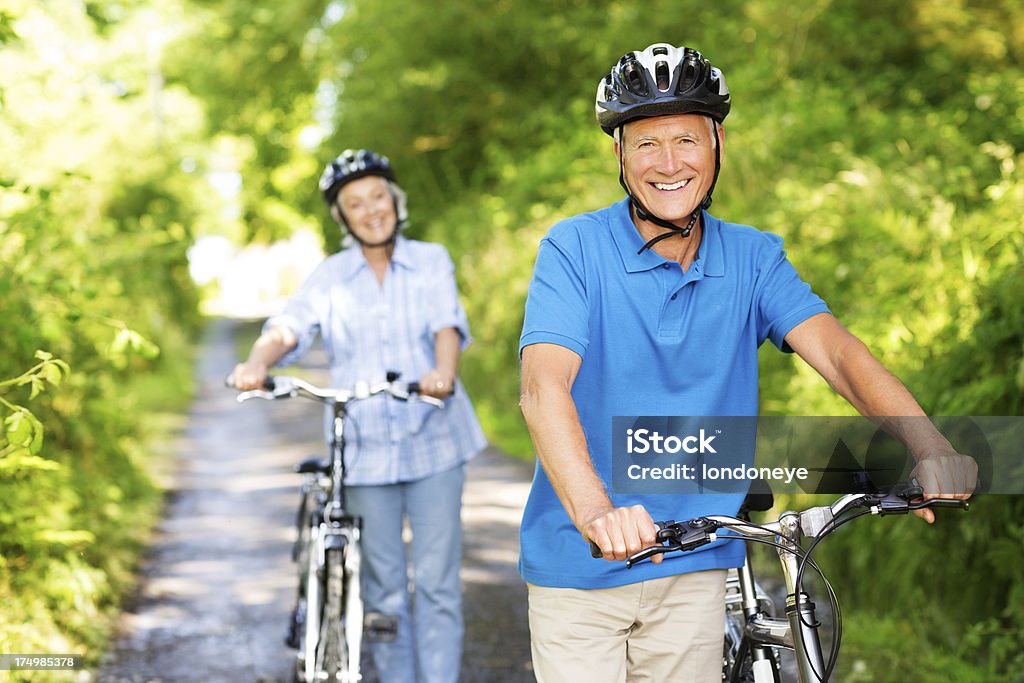 Couple âgé avec vélos dans le parc. - Photo de Faire du vélo libre de droits