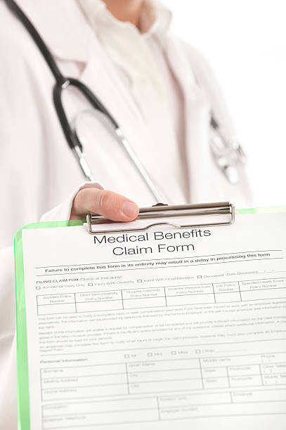 istock Doctor showing a medical benefits claim form 174985817
