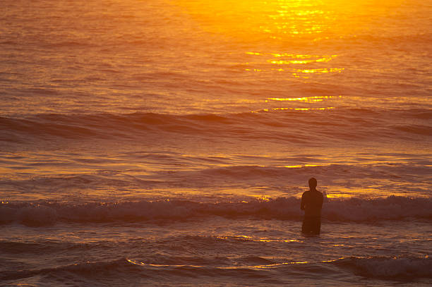 Man in an inspirational sunrise ocean silhouette
