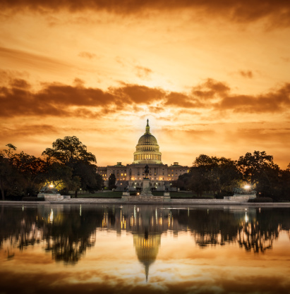 A glorious sunrise silhouettes the Capitol Building in Washington DC.
