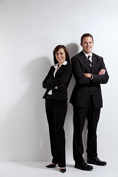 los ejecutivos de negocios de pie con los brazos cruzados - two people back to back businesswoman women fotografías e imágenes de stock