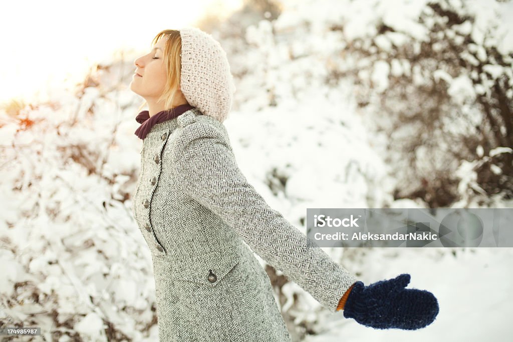 Loving the winter Young and beautiful smiling woman enjoying the snow Breathing Exercise Stock Photo