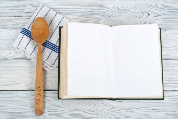 istock Recipe cook blank book on wooden background, spoon, rolling pin, checkered tablecloth. Top view 1749861241