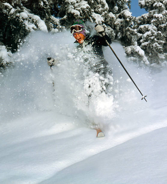 istock Young woman skiing fresh powder snow 174986171