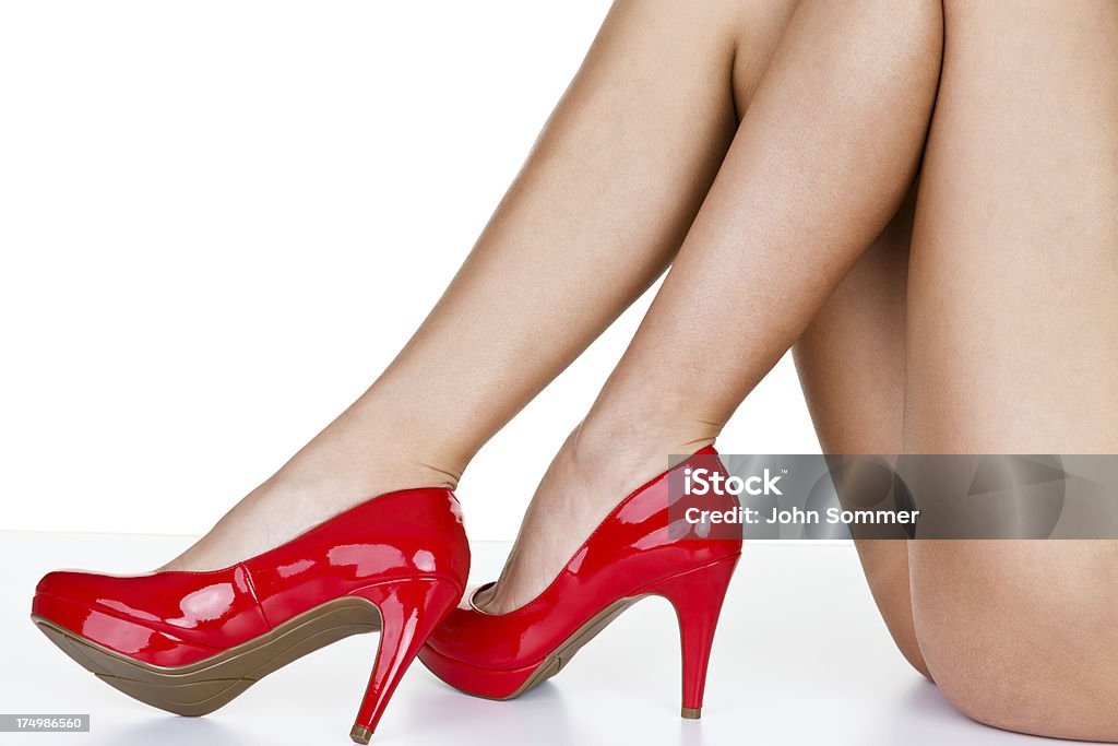 Woman wearing red heels Closeup of female legs wearing red high heels and isolated on white background  20-29 Years Stock Photo