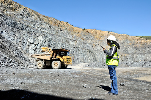 A female South African mine production manager oversees work in a gravel pit mine in the Western Cape