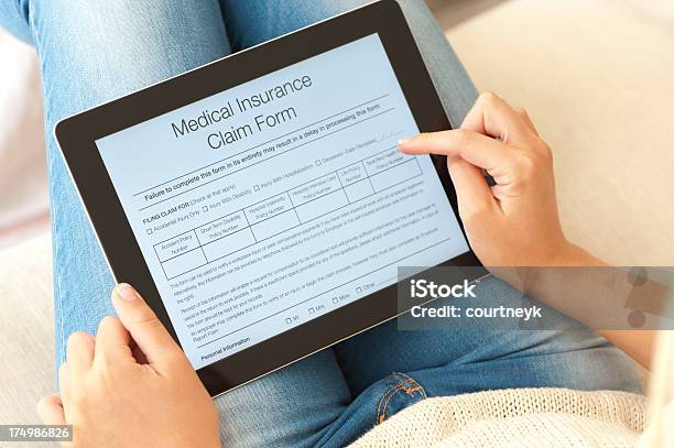 Foto de Preenchendo O Formulário Seguro De Saúde Em Um Tablet Digital e mais fotos de stock de Benefícios