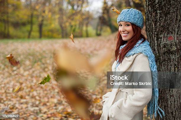 Girl Leaning On Tree In The Park With Falling Leaves Stock Photo - Download Image Now