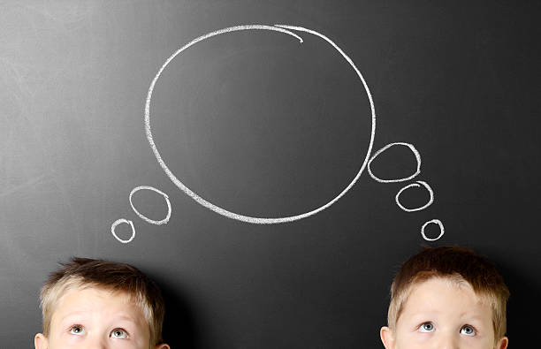 Two heads are better than one "Two boys against a chalkboard with a drawing of a speech bubble, concept of teamwork.Some images from the same series:" two heads are better than one stock pictures, royalty-free photos & images