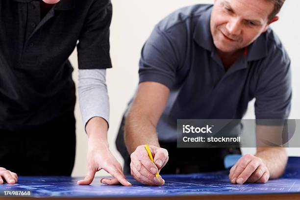 Discutere I Piani Di Costruzione Lavoratori Su Disegni - Fotografie stock e altre immagini di Adulto