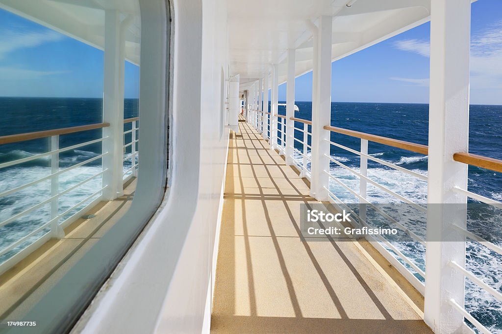 Railing on cruise ship with blue ocean Looking down the lower deck walkway of a cruise ship near Ushuaia - Argentina Cruise Ship Stock Photo