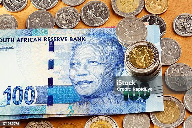 Nuevo Billete De Banco De Cien Rand Mandela En Escritorio Con Monedas Foto de stock y más banco de imágenes de Azul