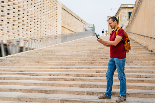 Handsome mid adult man using his smart phone in Valletta, Malta.