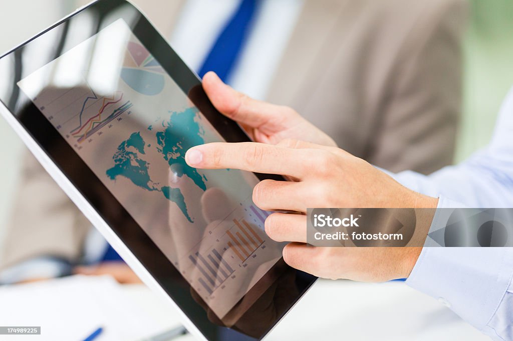 Analizzare report finanziari su digital tablet - Foto stock royalty-free di Carta geografica