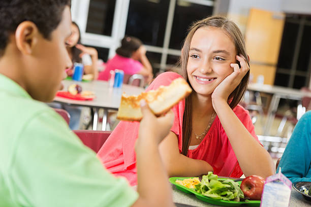 istock Middle school girl having lunch with friends in cafeteria 174990049