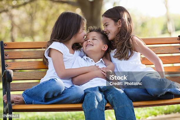 Kleine Schwestern Umarmen Bruder Auf Park Bench Stockfoto und mehr Bilder von 2-3 Jahre - 2-3 Jahre, 4-5 Jahre, Blick in die Kamera