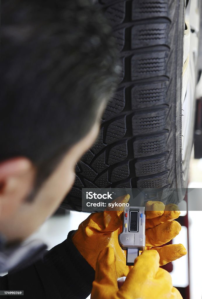 メカ��ニック測定タイヤの靴底深さ - タイヤのロイヤリティフリーストックフォト