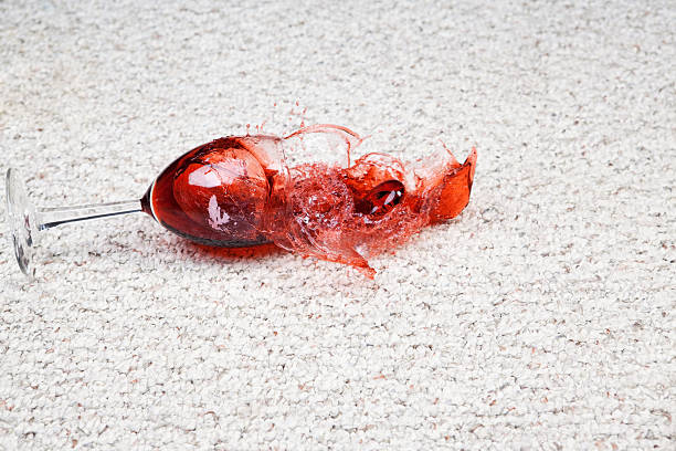 Wine Glass Falls onto Carpet "A wine glass and red wine have fallen to a clean berber carpet floor. Focus is on the glass and foreground carpet, the far right of the splash is slightly soft." wine glass knocked over stock pictures, royalty-free photos & images