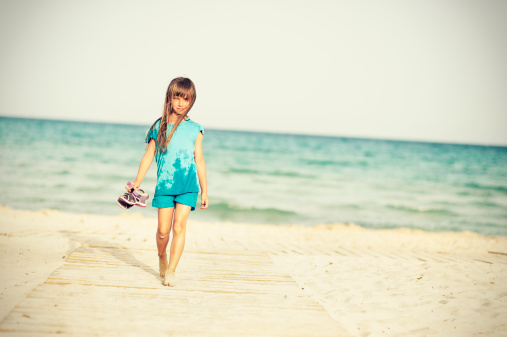 Portrait of little girl walking back from having fun on beach.