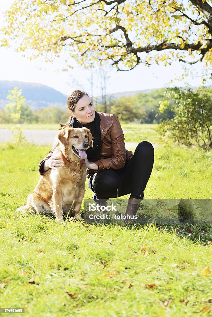 Brunette mujer con perro al aire libre - Foto de stock de 35-39 años libre de derechos