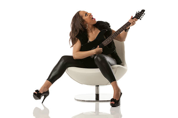 Girl, woman playing guitar in the studio.