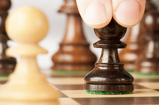 istock Hand moves pawn forward in opening chess move 174992622
