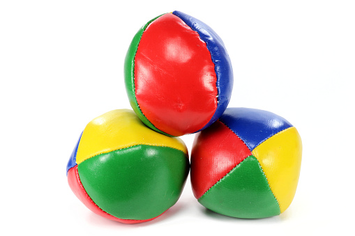Close up shot of three colorful juggling balls on white background