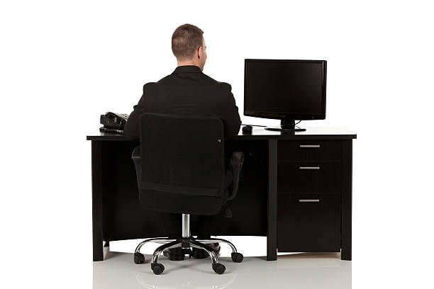 Businessman working at a desk Businessman working at a deskhttp://www.twodozendesign.info/i/1.png man in the desk back view stock pictures, royalty-free photos & images