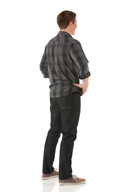 istock Rear view of a young man standing with hands on hips 174993934