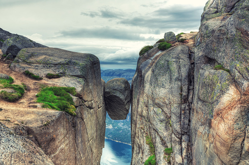 Famous rock wedged and completely stuck between the walls of two steep cliffs in Kjerag Mountains, Norway