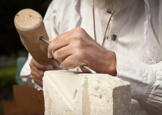 Hands carving in a white stone stock photo