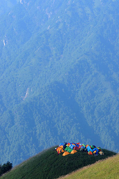 Tent party "Wukong Mountain is located in Pingxiang City Jiangxi Province China. Its main peak rises 1918.3 meters above sea level. Wukong Mountain has 100,000 mu grassland which is very suitable for outdoor camping. The 1st Mt. Wukong International Camping Festival was opened in 2008. After four yearsaa development, the 5th Mt. Wukong International Camping Festival, opened in September 14, 2012, attracted more than 10,000 outdoor enthusiasts from all around the country. It has become one of the grand outdoor meetings with the largest scale in Asia." beautiful multi colored tranquil scene enjoyment stock pictures, royalty-free photos & images
