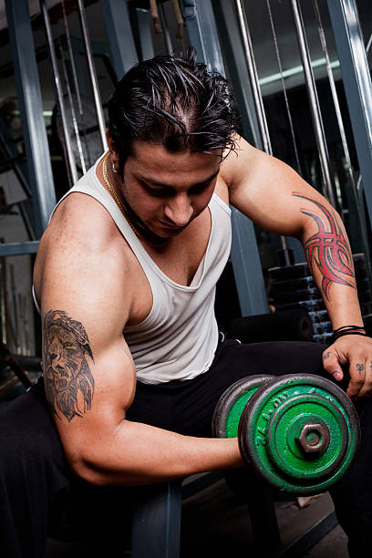 istock Strong Asian Indian Man Using Dumbbell Exercising in Gym 174995456