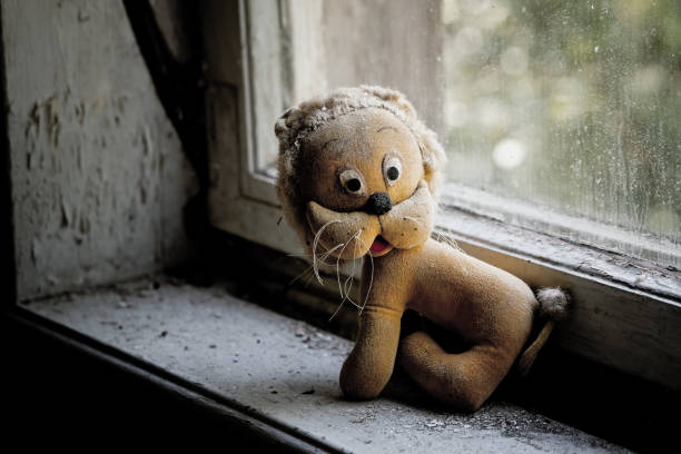 an old stuffed animal in an abandoned house at a window