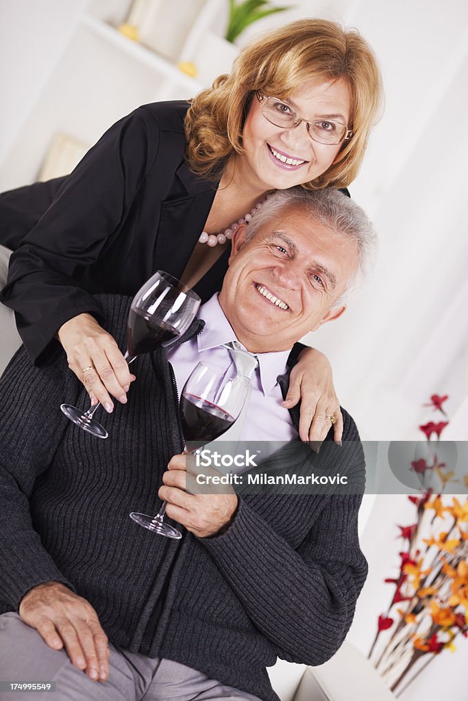 Senior couple Senior couple in home interior enjoying in glass of wine. 50-59 Years Stock Photo