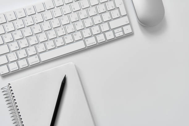 istock Office table desk. Workspace with sketchpad, keyboard, office supplies, pencil, on white table. 1749957424