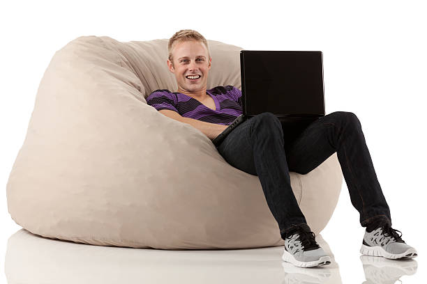 istock Man reclining on bean bag and using a laptop 174996179